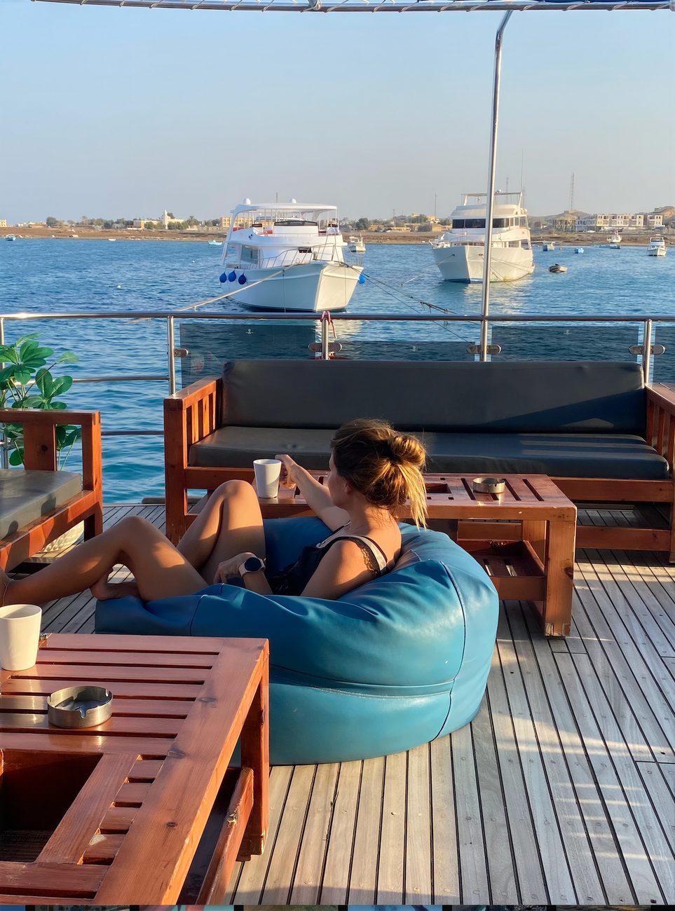 A guest relaxing on a bean bag with a warm drink in the golden light